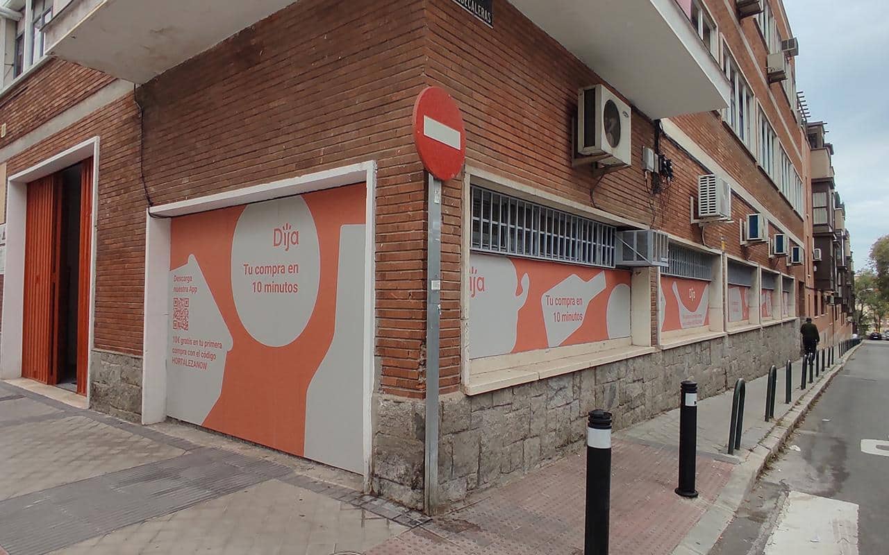 Imagen de varios escaparates decorados con vinilos de la tienda de reparto a domicilio DIJA