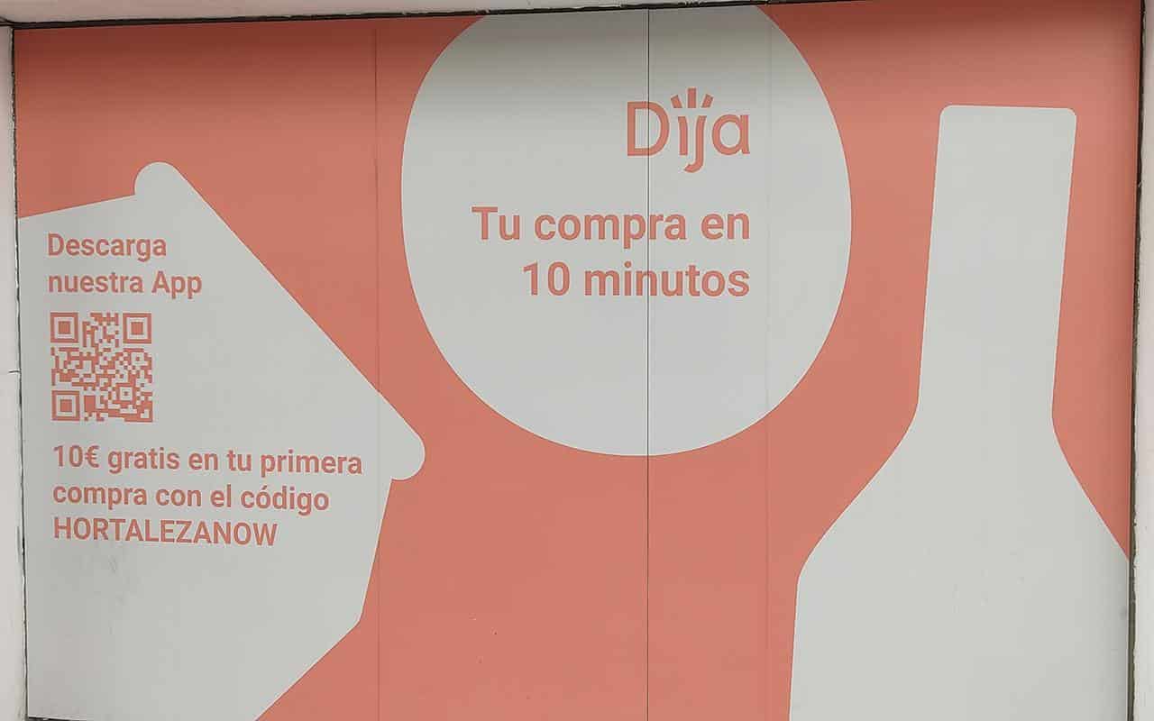 Imagen de un escaparate decorado con un vinilo de la tienda de reparto a domicilio DIJA